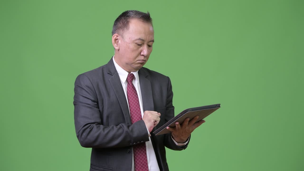 디지털 태블릿으로 일하는 성숙한 일본인 사업가