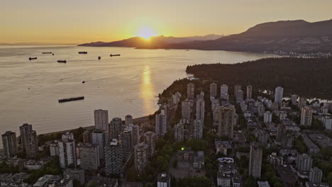 밴쿠버 bc 캐나다 aerial v61 영화 드론 플라이오버 웨스트 엔드 (west end) 로 잉글랜드 베이 비치 (english bay beach) 를 향해 해가 지는 풍경을 포착하고 지평선에서 반이는 해가 가는 풍경 - mavic 3 pro cine로 촬영 - 2023 년 7 월