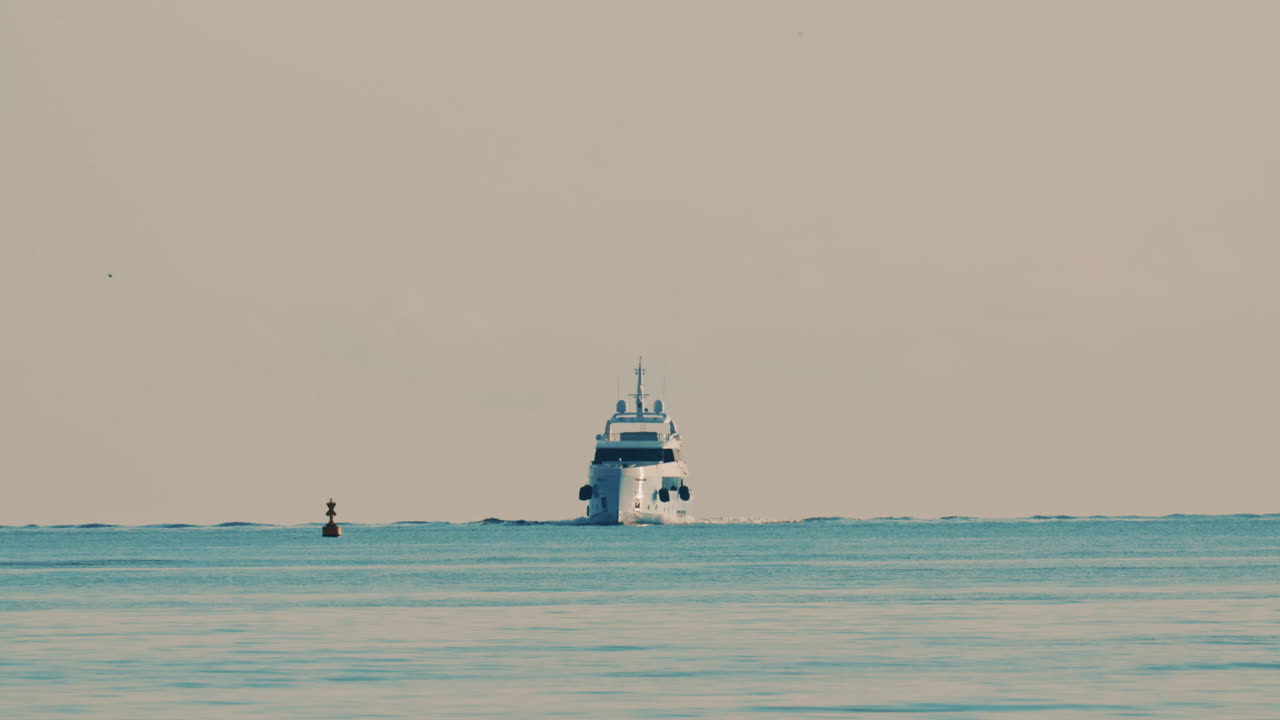 Una boa di navigazione in primo piano e uno yacht all'orizzonte nel Mar Mediterraneo vicino alla Francia