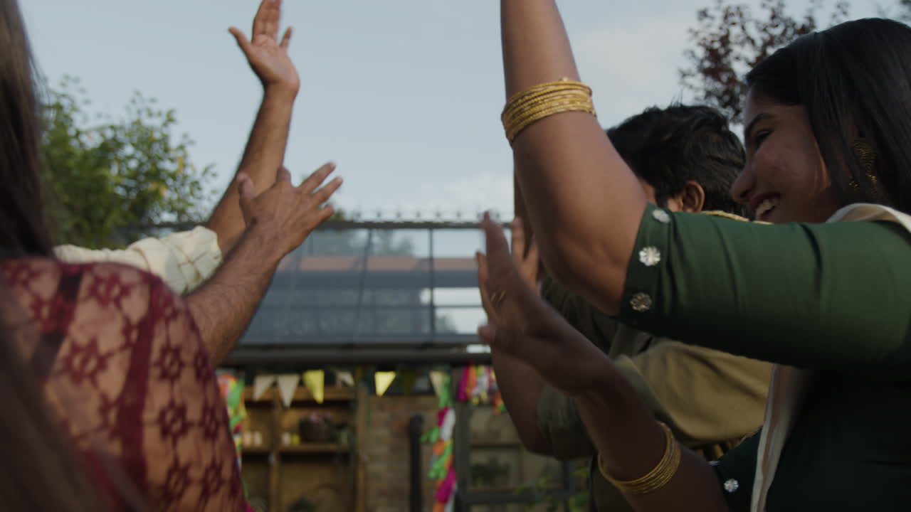 A group of friends and family dancing and celebrating outdoors