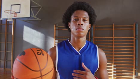 portrait of african american male basketball player holding ball