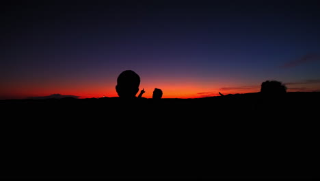 Silhouette-Von-Menschen,-Die-Mit-Dem-Finger-Zum-Himmel-Zeigen