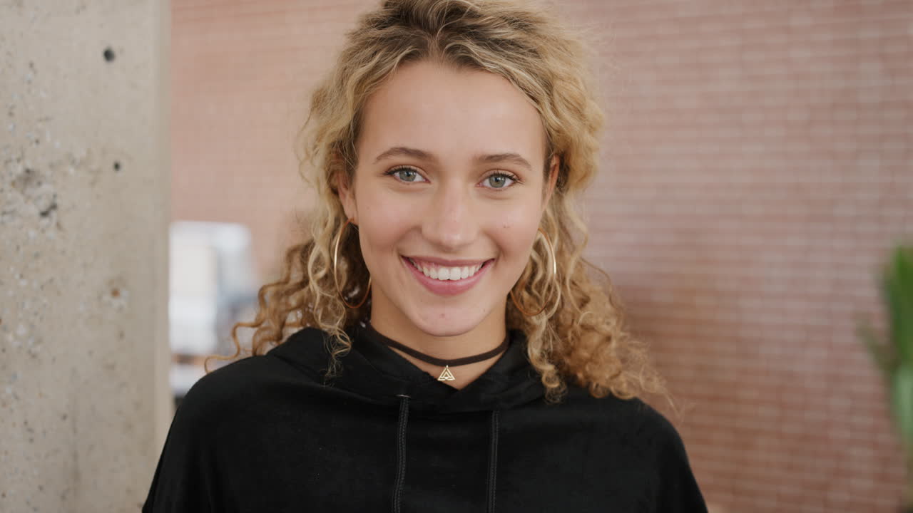 retrato de una joven rubia feliz, una estudiante sonriente, alegre, disfrutando de un exitoso estilo de vida universitario.