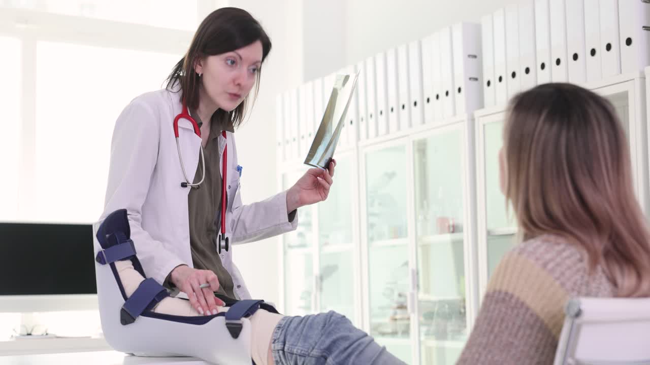 Medico che esamina la radiografia della gamba di un paziente