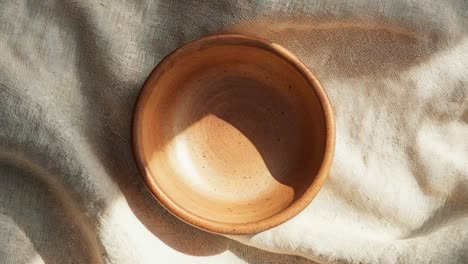 empty brown ceramic bowl on linen fabric