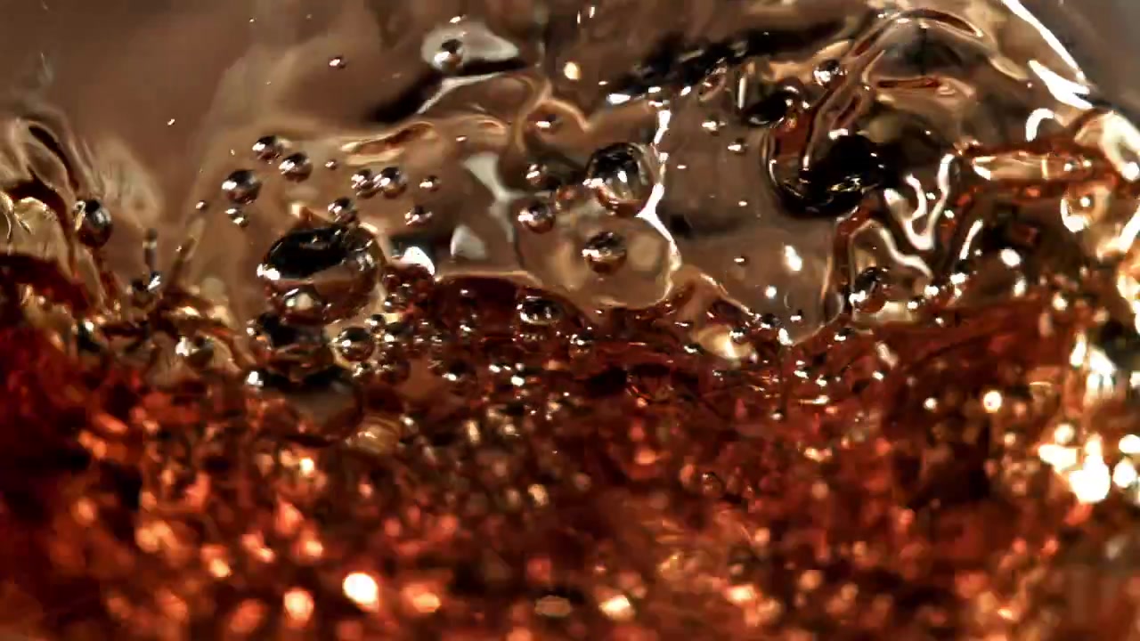 Liquido ambrato in vortice con bolle effervescenti