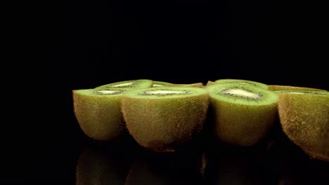 fruit de kiwi vert frais coupé en deux super macro gros plan tourner voler plus de 4k tourner de haute qualité sur fond sombre