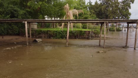 lateral view of impact of global warming on dried parana river with wooden dock over, argentina