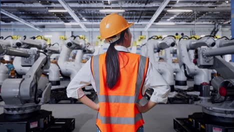 ingeniero observando robots industriales en una fábrica