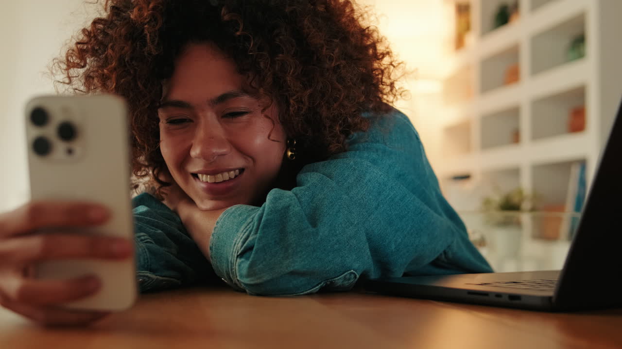 Joven feliz sonriendo mientras mira su smartphone