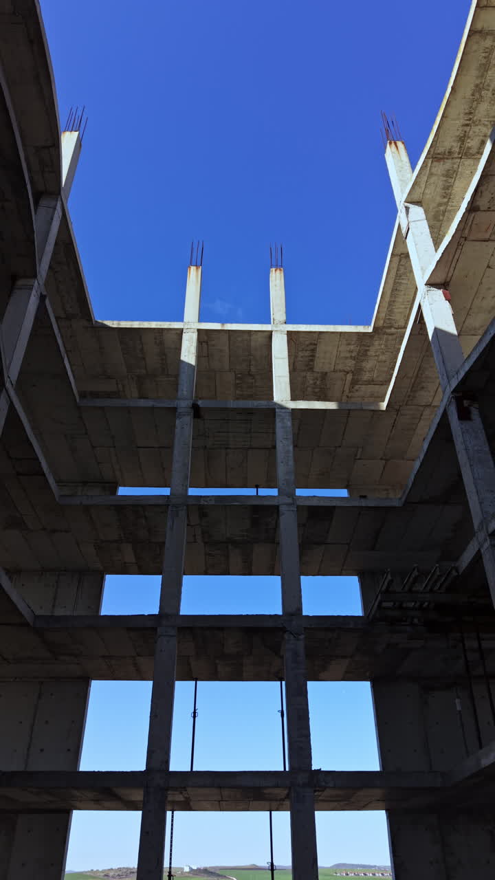 Explorando una obra en construcción inacabada con imponentes pilares de hormigón y cimientos profundos bajo la luz del sol