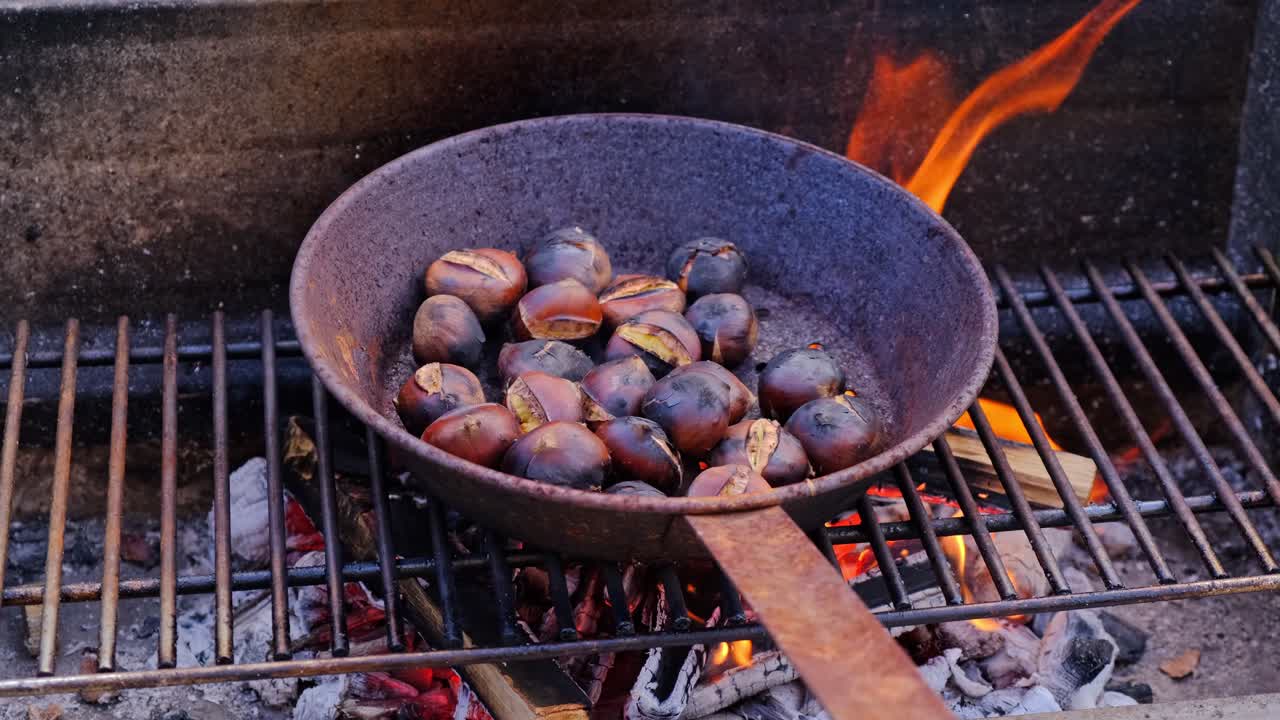 Chestnuts cooked, roasted in pan over fire, traditional rustic dessert