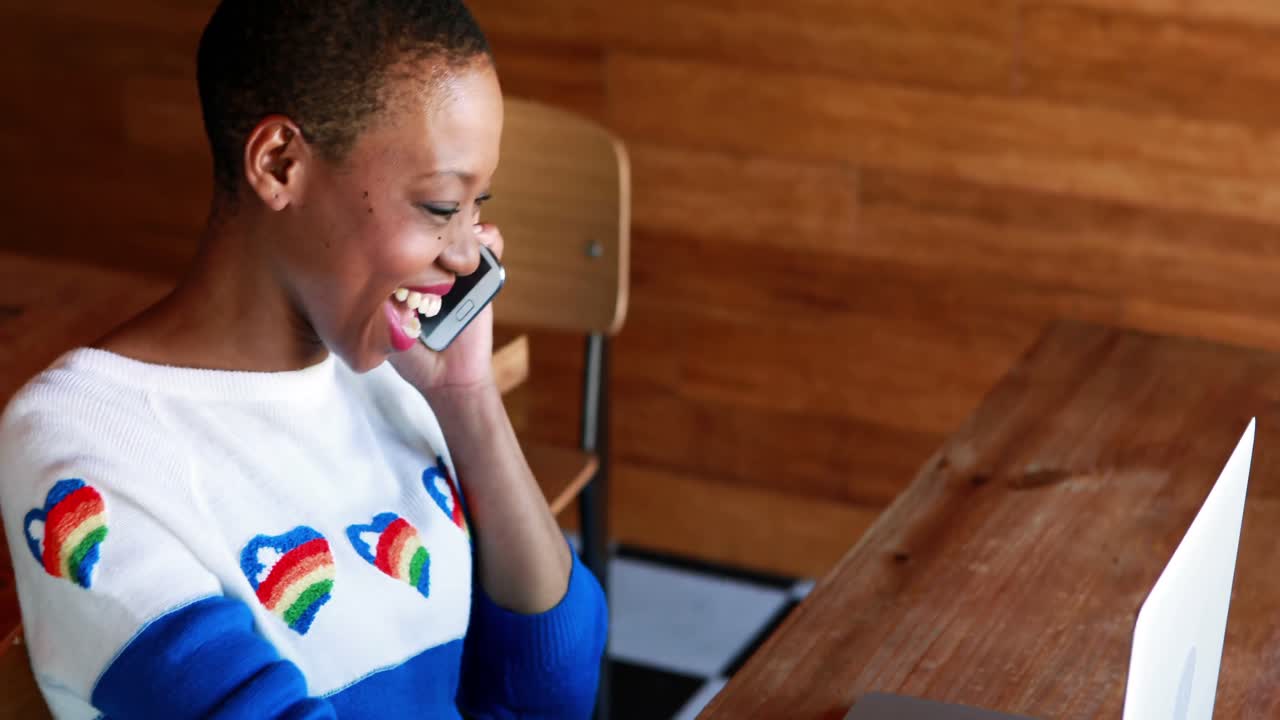 Donna che parla al telefono cellulare durante l'utilizzo di laptop