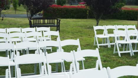 sillas blancas dispuestas en el jardín para la boda