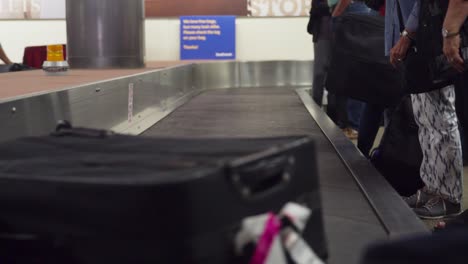 baggage goes down a conveyor and is picked up by a passenger