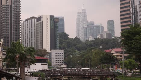 view of river looking up towards petronas twin towers in kuala lumpur, malaysia