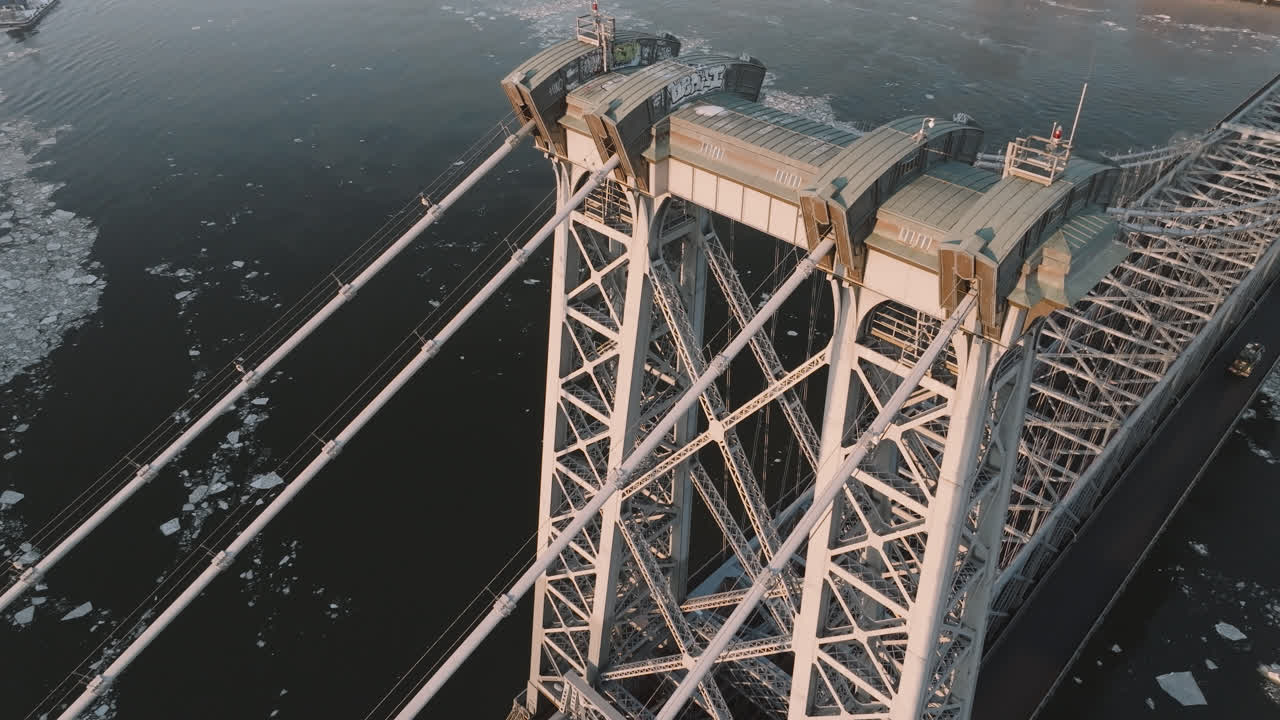 Drone shot of the Williamsburg Bridge above a frozen East River. Shot at sunrise in New York City