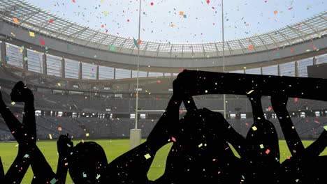 confeti colorido cayendo contra la silueta de los fanáticos aplaudiendo y el estadio deportivo en el fondo