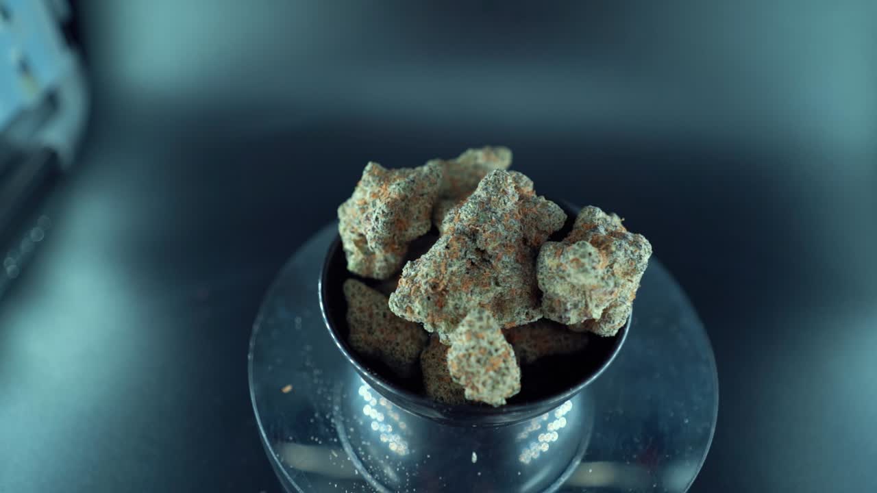 상단에서 아래로 자세한 매끄러운 크레인 움직임, 대마초 식물의, 하이브리드 오렌지 품종, 인디카 유형, 녹색 대마초 꽃, 느린 동작 120fps, 스튜디오 led 조명, 반이는 회전 스탠드