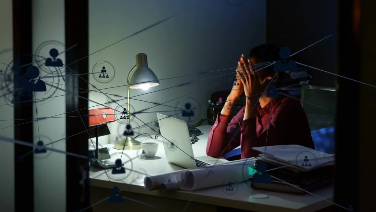 Reviewing files woman in maroon shirt working late at office desk with laptop overlay, copy space