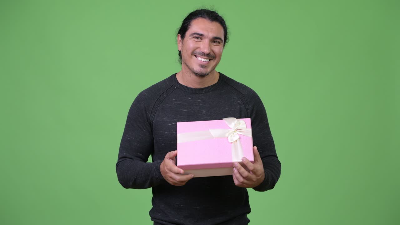 Handsome man thinking while holding gift box