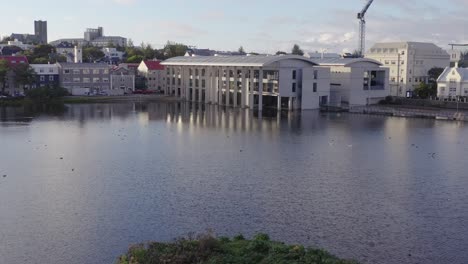 volando hacia el ayuntamiento moderno en reykjavik, capital de islandia, antena