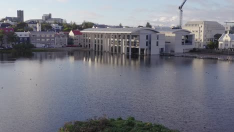 vliegen naar het moderne stadhuis in reykjavik, hoofdstad van ijsland, vanuit de lucht