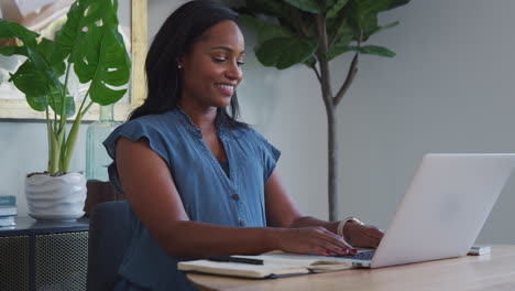 Mujer-Afroamericana-Embarazada-Usando-Una-Computadora-Portátil-En-La-Mesa-Trabajando-Desde-Casa