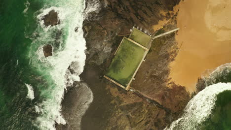 Drone-aerial-shot-over-a-tidal-sea-side-beach-pool
