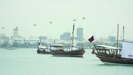 barcos dhow en qatar con helicópteros militares en la distancia
