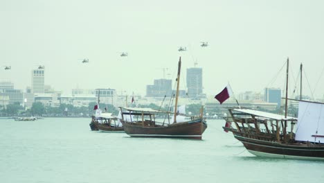 dhow boats in qatar with military helicopters in the distance