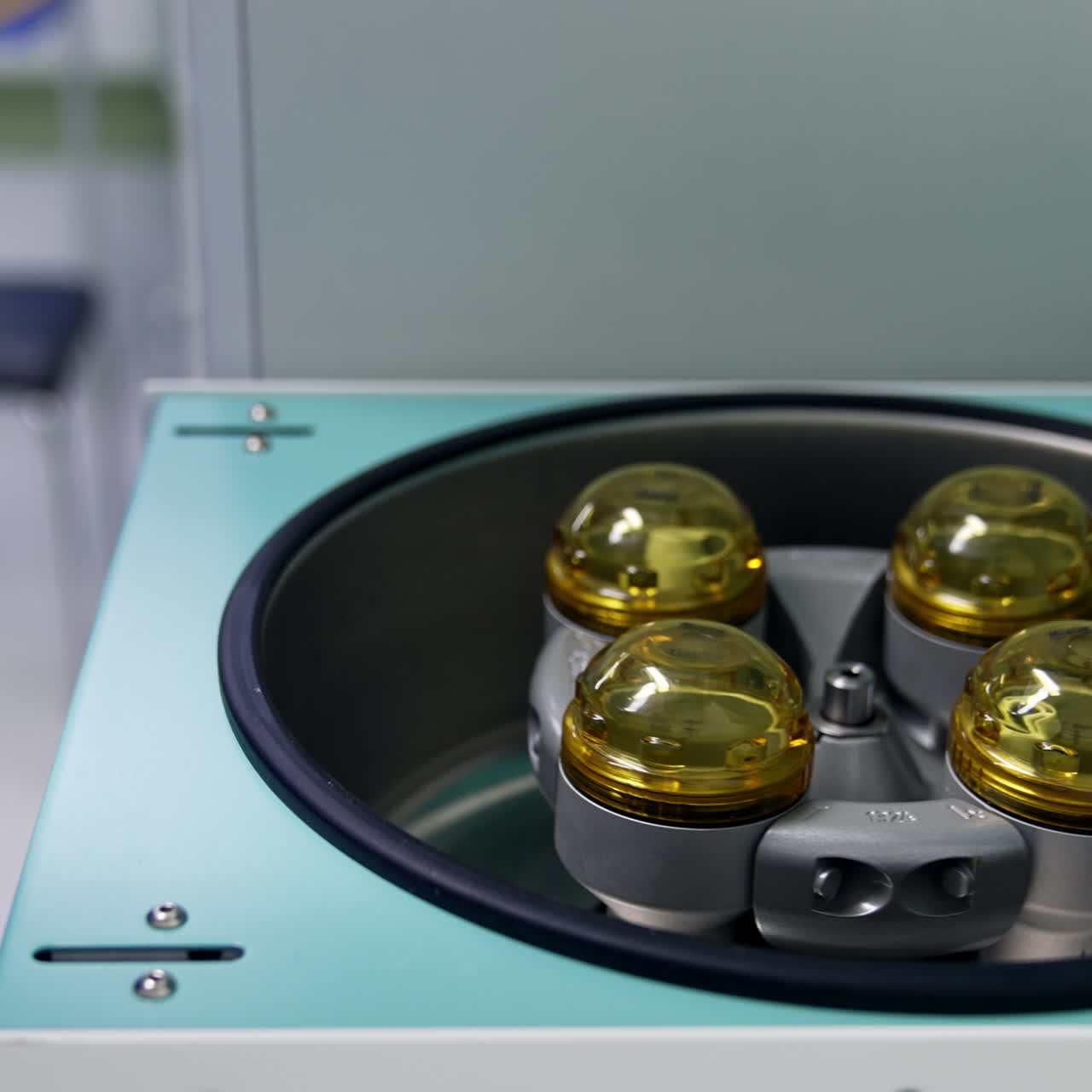 Medic's hand load the centrifuge system with blood samples. Nurse closes the lid of a machine. Close up