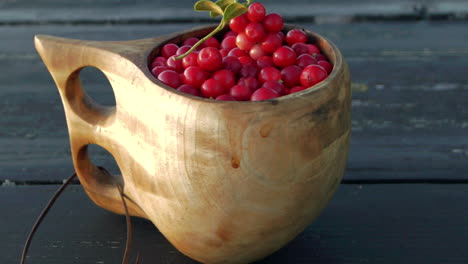 delicious nordic lingonberries in a handmade wooden cup, panning dolly shot