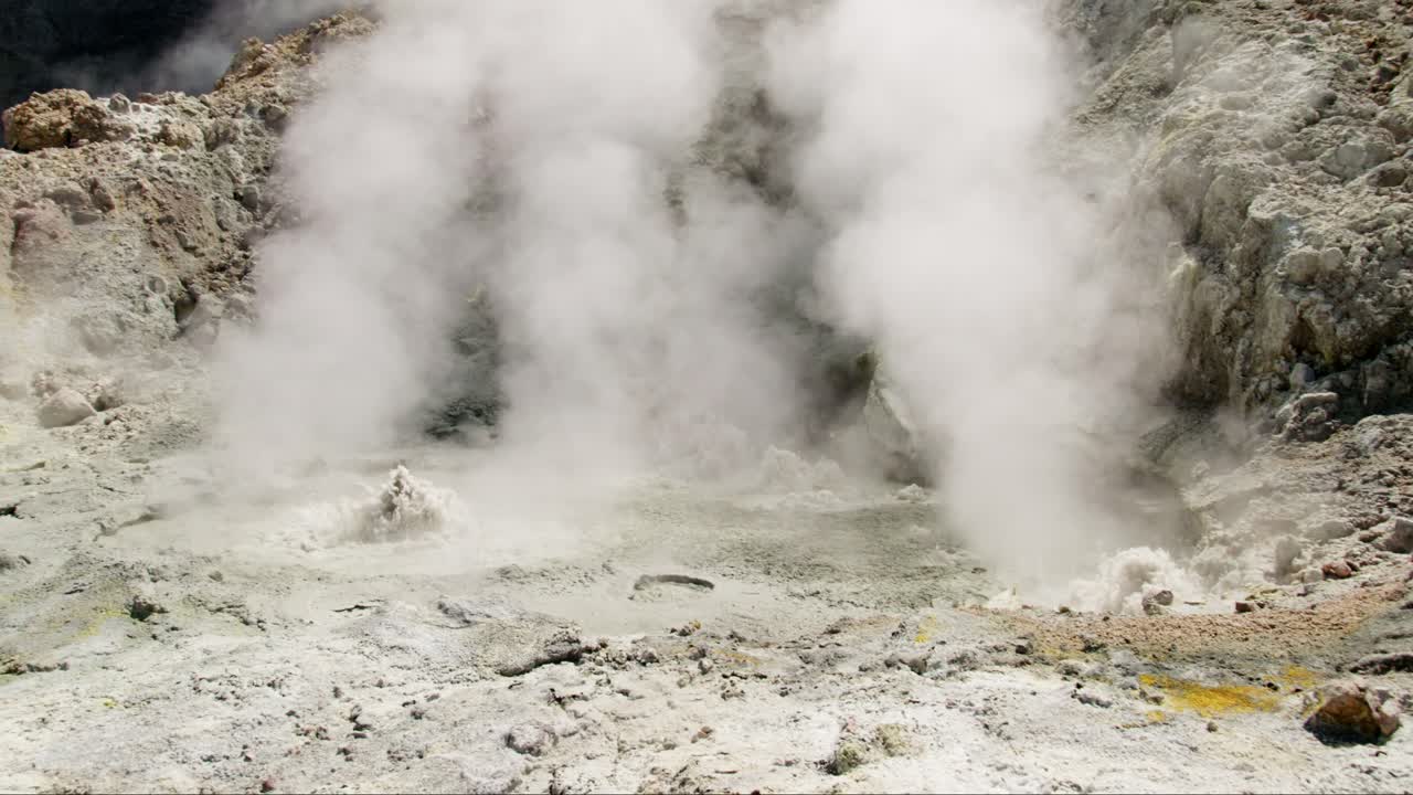 piscinas termales geotérmicas con nubes de humo blanco en un volcán activo
