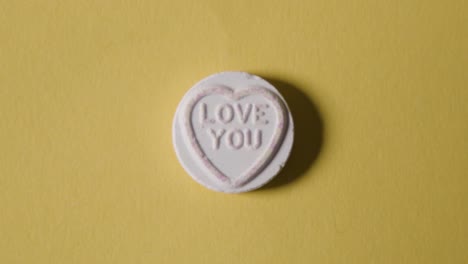 heart candy with love you message on yellow background