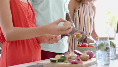 Young-Caucasian-woman-and-African-American-man-prepare-food-at-home