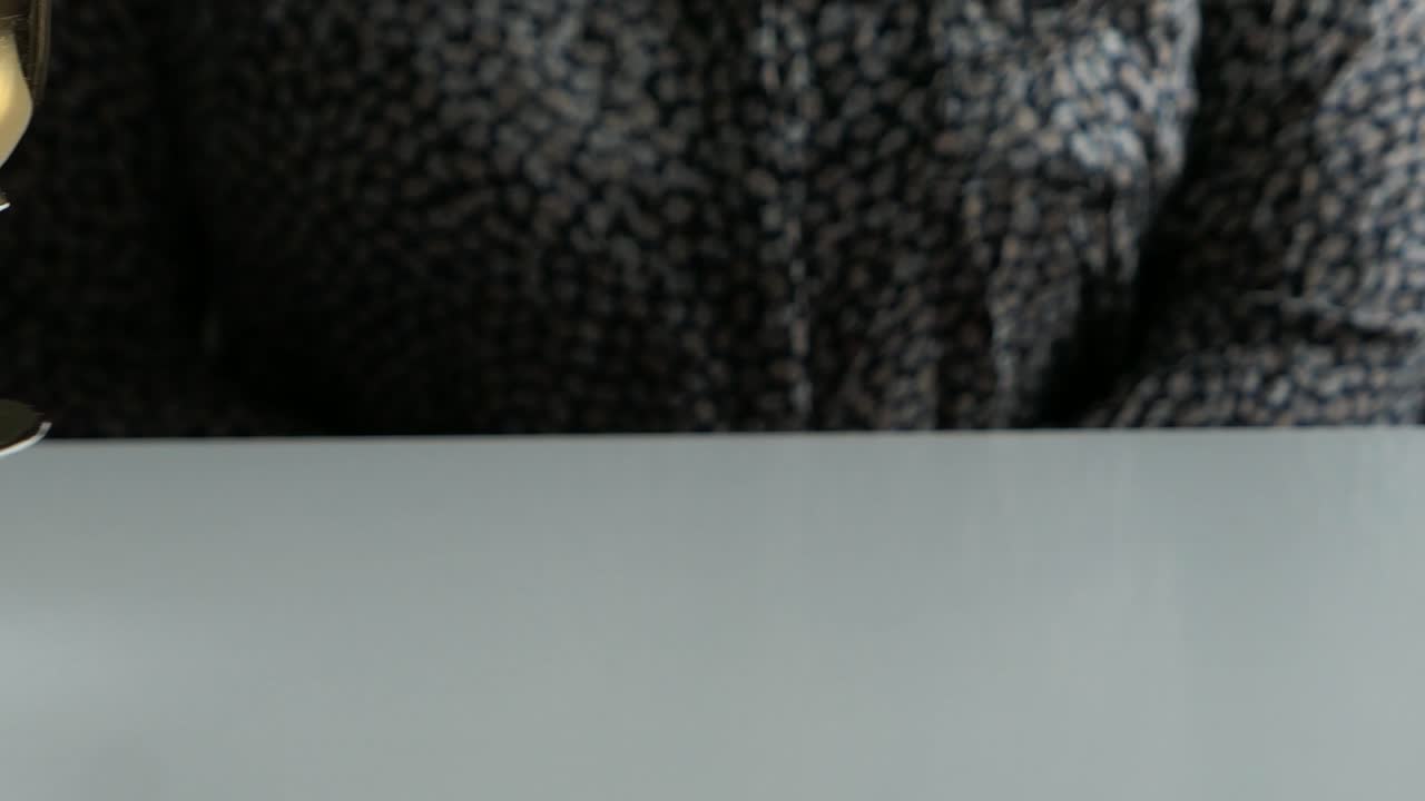 Barista cleaning up table in cafe, taking away empty coffee cup from a customer, close up