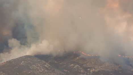 el avión cisterna dc-10 vuela a través del humo oscuro del incendio de fairview a lo largo del borde del incendio en hemet, california