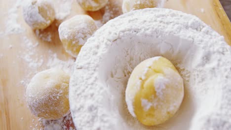 dough ball placed over flour on a wooden table 4k