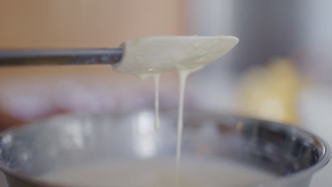 close-up of dough spatula checking consistency of pancake batter