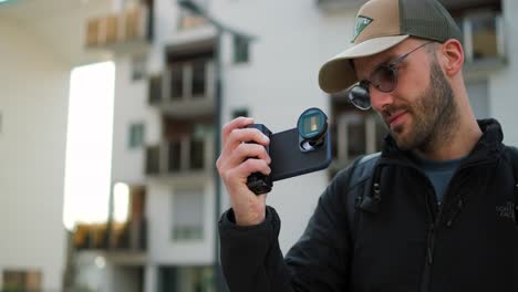 a man filming on iphone 14 pro with a professional grip and anamorphic lens