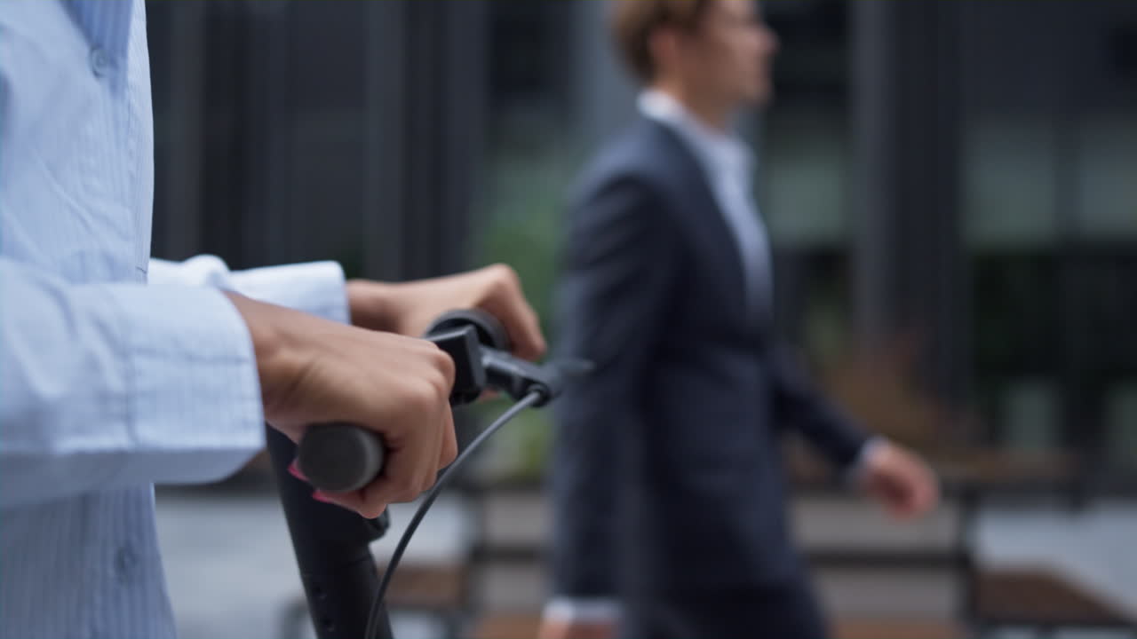 Woman hand on electric scooter close up. Alternative city transport concept.