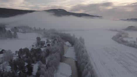 río congelado con nubes bajas durante el invierno