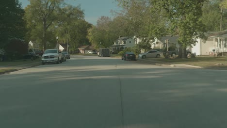 driving through a suburban neighborhood with autumn leaves on the ground