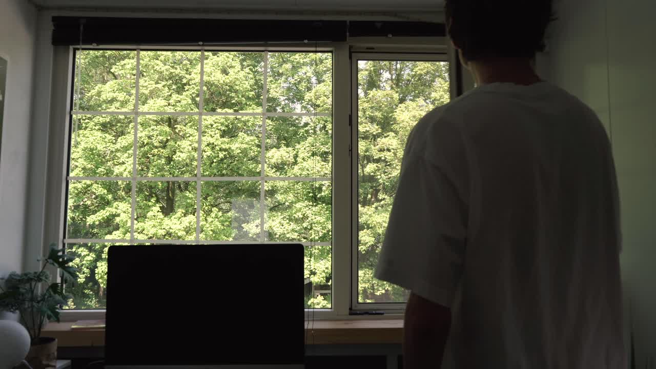 남자가 사무실 창문을 열고 더 많은 공기 흐름을 허용합니다.