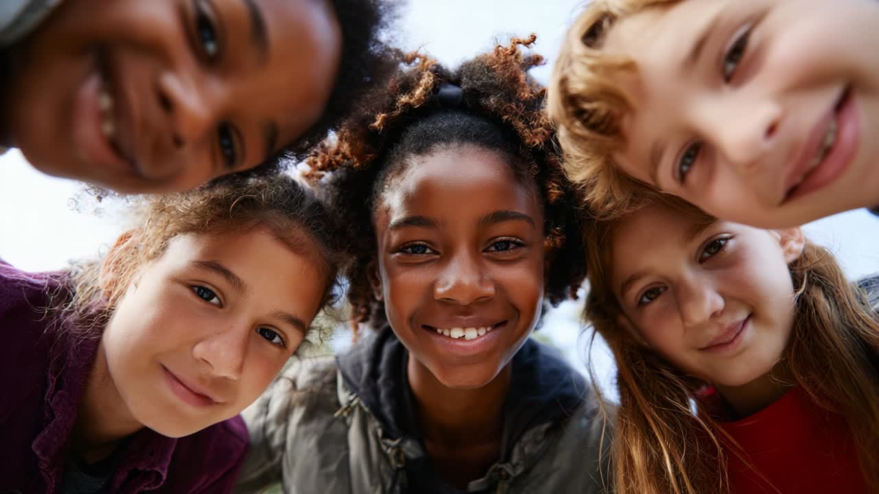 A Joyful Moment Captured: A Group of Five Children Smiling and Greeting the Camera with Bright Expressions in a Fun and Playful Outdoor Setting Beneath a Clear Sky