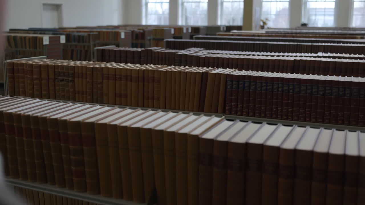 A person views rows of old books in a library