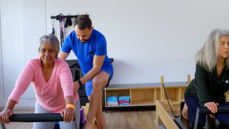 entrenador ayudando a las mujeres mayores en la realización de yoga 4k