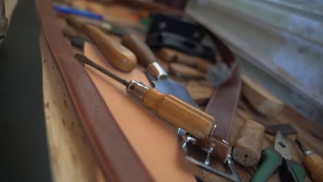 Leatherworker-workshop-tools-lying-around-on-a-table-close-up-shot
