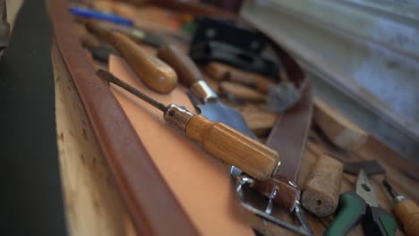 leatherworker workshop tools lying around on a table close up shot